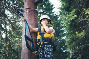 Below view of uncertain boy on canopy tour. photo