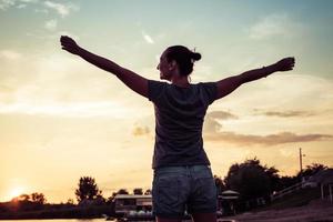 Carefree woman having fun at sunset during summer. photo