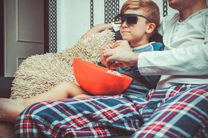 Little boy watching movie with his father. photo