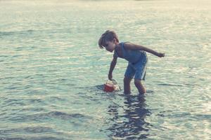 niño pequeño disfrutando en el recreo en el mar. foto