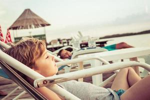 Relaxed boy enjoying in sunset at the beach. photo