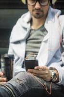 Close up of man searching for favorite music on smart phone. photo