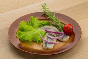 Herring fillet on the plate and wooden background photo