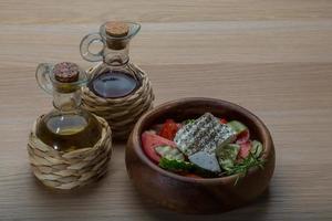 Greek salad in a bowl on wooden background photo