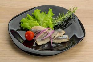 Herring fillet on the plate and wooden background photo