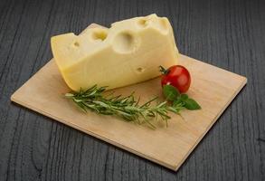 Maasdam cheese on wooden background photo