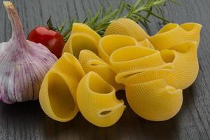 Shell pasta on wooden background photo