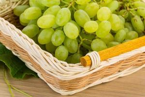 Green grapes in a basket on wooden background photo