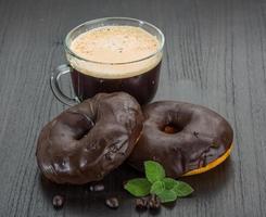 Coffee with donuts on wooden background photo