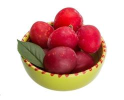 Damson plum in a bowl on white background photo