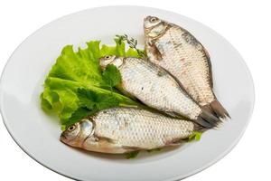 Crucian fish on the plate and white background photo