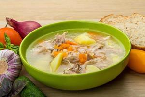 Chicken soup in a bowl on wooden background photo