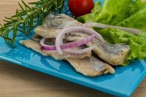 Herring fillet on the plate and wooden background photo