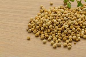 Coriander seeds on wooden background photo