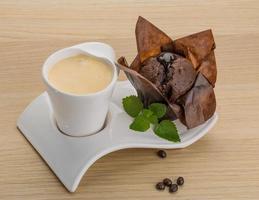 café con muffin sobre fondo de madera foto