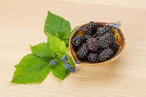 Blackberry in a bowl on wooden background photo