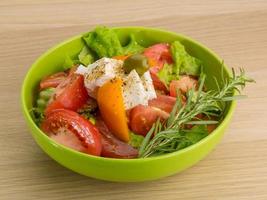 Greek salad in a bowl on wooden background photo