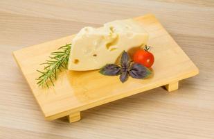 Maasdam cheese on wooden background photo