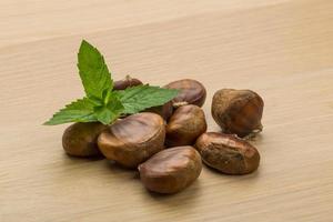 Chestnut on wooden background photo