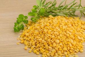 Raw yellow lentils on wooden background photo
