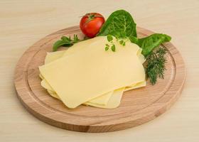 Sliced cheese on wooden board photo