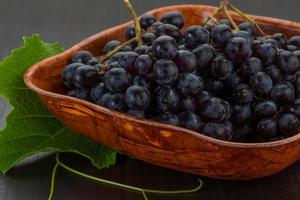 Grape in a bowl on wooden background photo
