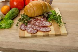 Salami on wooden plate photo