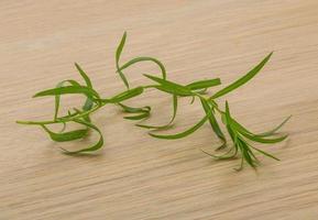 Tarragon leaves on wooden background photo