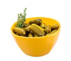 Marinated cucumbers in a bowl on white background photo