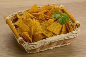 Nachos in a basket on wooden background photo