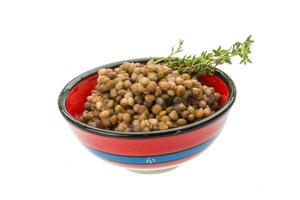 Backed lentils in a bowl on white background photo