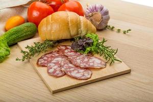 Salami on wooden plate photo