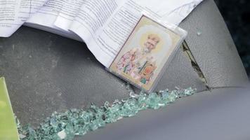 Der Innenraum des Autos wurde nach dem Unfall beschädigt. Auf dem Sitz liegt die Ikone des Amuletts von St. nikolaus der wundertäter nahaufnahme und scherben. ukraine, irpen - 12. mai 2022. video