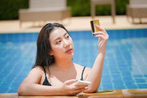 online payment, A teenage girl who swims is using her credit card with her phone to make purchases. online via internet. photo