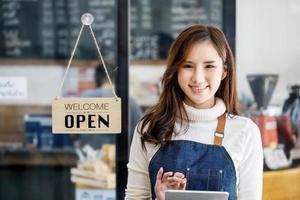 tiendas de inicio, propietarios de pequeñas empresas de pie para mostrar un cartel en la recepción para los clientes que vendrán a utilizar el servicio en la tienda después de que la situación del coronavirus comenzó a desarrollarse. foto