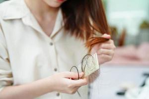 las mujeres asiáticas tienen problemas con la pérdida de cabello largo y se adhieren al cepillo de peine. foto