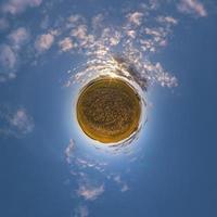 tiny planet in blue sky with beautiful clouds. Transformation of spherical panorama 360 degrees. Spherical abstract aerial view. Curvature of space. photo