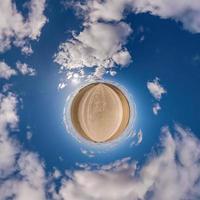 pequeño planeta verde en el cielo azul con hermosas nubes. transformación de panorama esférico 360 grados. vista aérea abstracta esférica. curvatura del espacio. foto