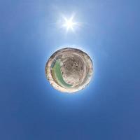 Little planet transformation of spherical panorama 360 degrees. Spherical abstract aerial view in field with clear sky and awesome beautiful clouds. Curvature of space. photo