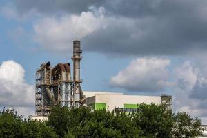 tuberías del aserradero de la planta de la empresa de carpintería cerca del río. concepto de contaminación del aire. paisaje industrial contaminación ambiental residuos de central térmica foto