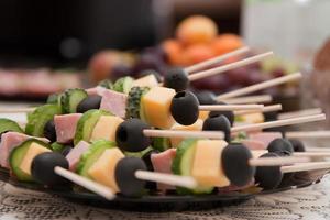 canapes from olives cheese marmalade and sausages on skewers photo