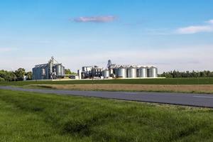 Modern Granary elevator. Silver silos on agro-processing and manufacturing plant for processing drying cleaning and storage of agricultural products, flour, cereals and grain. photo