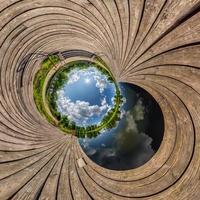 blue sphere little planet inside transformation of wooden pier and lake. photo