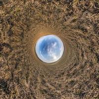 Inversion of little planet transformation of spherical panorama 360 degrees. Spherical abstract aerial view on field with awesome beautiful clouds. Curvature of space. photo