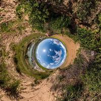 Inversion of little planet transformation of spherical panorama 360 degrees. Spherical abstract aerial view on field with awesome beautiful clouds. Curvature of space. photo