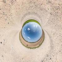 Inversion of blue little planet transformation of spherical panorama 360 degrees. Spherical abstract aerial view on road with awesome beautiful clouds. Curvature of space. photo