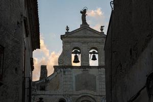 retroiluminado dos viejas campanas de una antigua iglesia en italia. foto