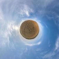 pequeño planeta transformación de panorama esférico 360 grados. vista aérea abstracta esférica en el campo con cielo despejado y hermosas nubes impresionantes. curvatura del espacio. foto