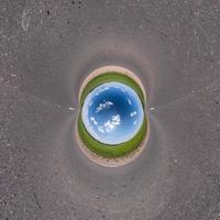 Inversion of blue little planet transformation of spherical panorama 360 degrees. Spherical abstract aerial view on road with awesome beautiful clouds. Curvature of space. photo
