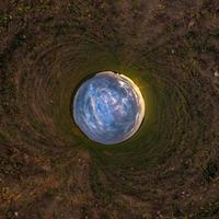 blue sky ball among green grass. Inversion of tiny planet transformation of spherical panorama 360 degrees. Spherical abstract view. Curvature of space. photo